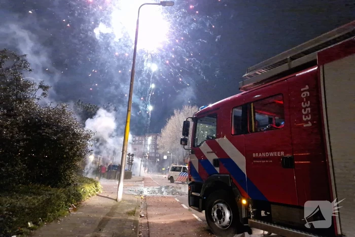 Brandweer blust brandend vuurwerkafval