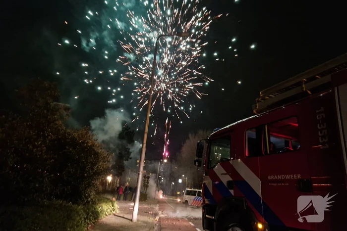 Brandweer blust brandend vuurwerkafval