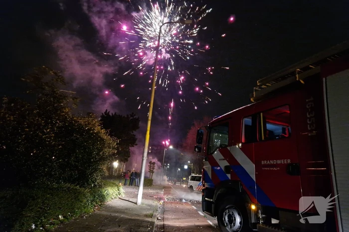 Brandweer blust brandend vuurwerkafval