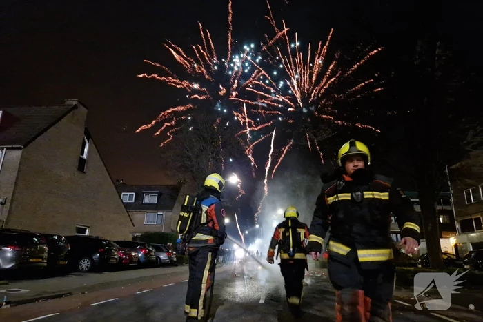Brandweer blust brandend vuurwerkafval