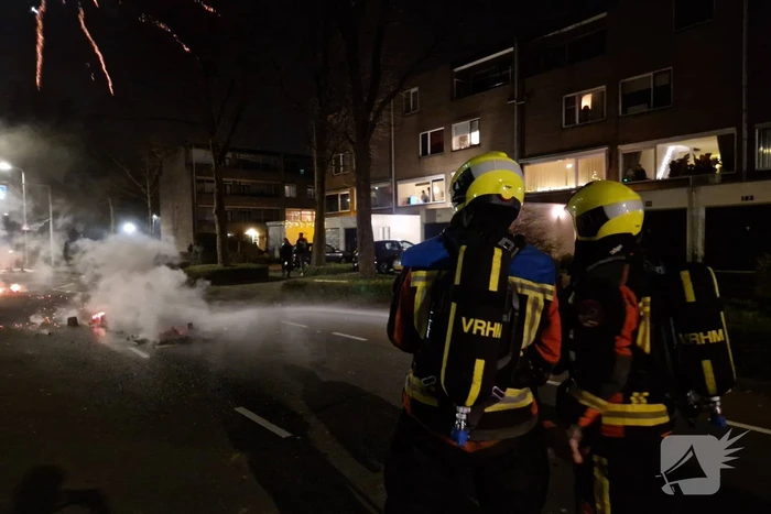 Brandweer blust brandend vuurwerkafval