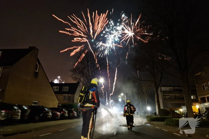 Brandweer blust brandend vuurwerkafval