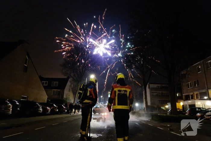 Brandweer blust brandend vuurwerkafval