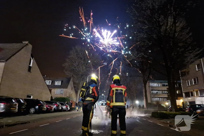 Brandweer blust brandend vuurwerkafval