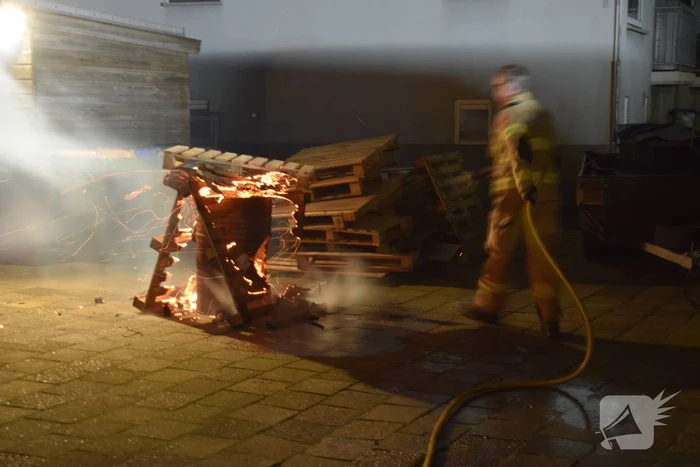 Brandweer blust brandende vuurton in achtertuin