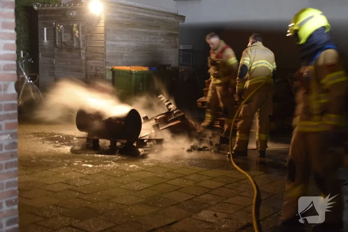 Brandweer blust brandende vuurton in achtertuin