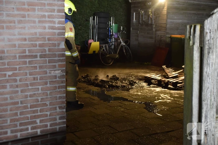 Brandweer blust brandende vuurton in achtertuin