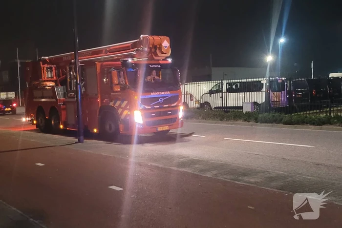 Brandweer blust brandend heg naast pand
