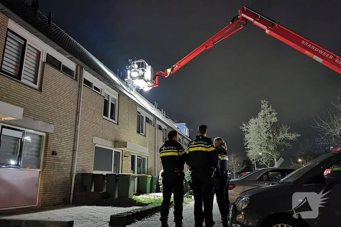 Persoon klimt op dak van woning