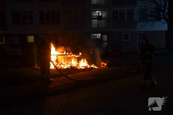 Grofvuil in brand naast afvalcontainer