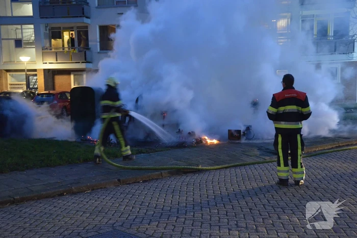 Grofvuil in brand naast afvalcontainer