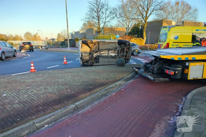 Auto belandt op zijn kant op rotonde