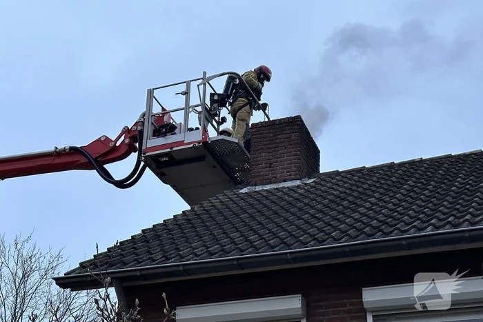 Brandweer veegt schoorsteen na brand
