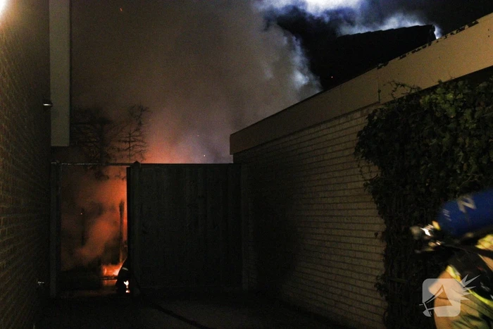 Uitslaande brand in tuinhuis slaat over naar woning