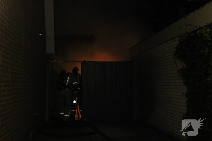 Uitslaande brand in tuinhuis slaat over naar woning
