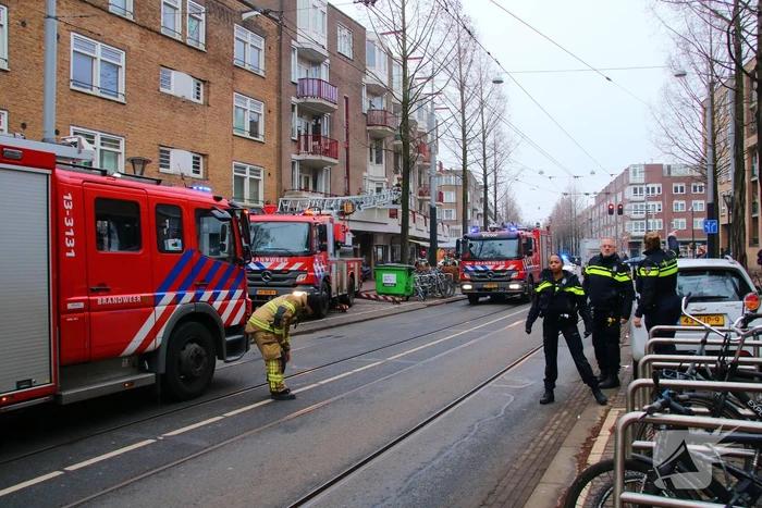 Brandweer met veel wagens naar woningbrand