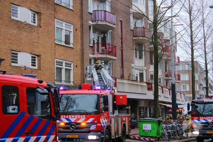 Brandweer met veel wagens naar woningbrand