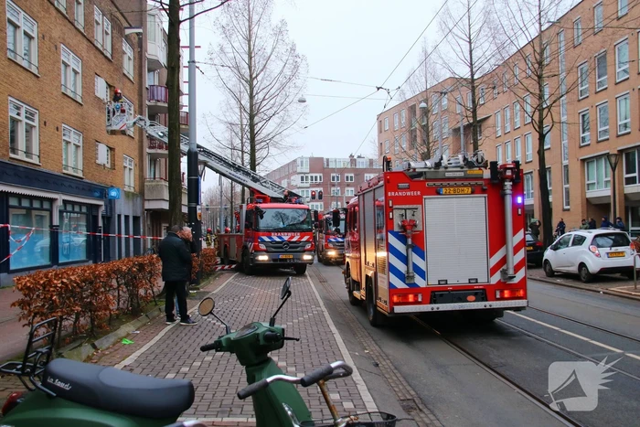 Brandweer met veel wagens naar woningbrand