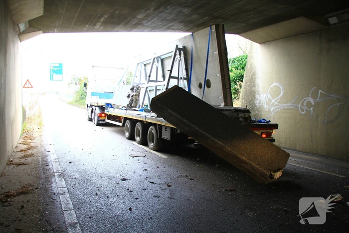 Vrachtwagenchauffeur rijdt met lading tegen spoorviaduct