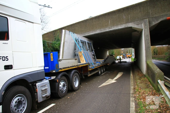 Vrachtwagenchauffeur rijdt met lading tegen spoorviaduct