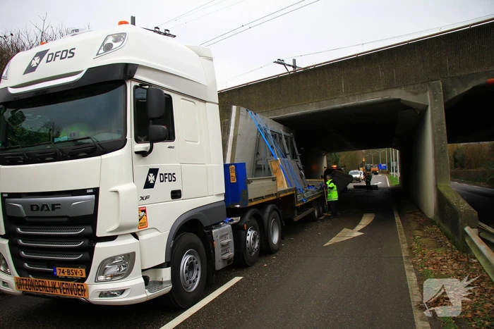 Vrachtwagenchauffeur rijdt met lading tegen spoorviaduct