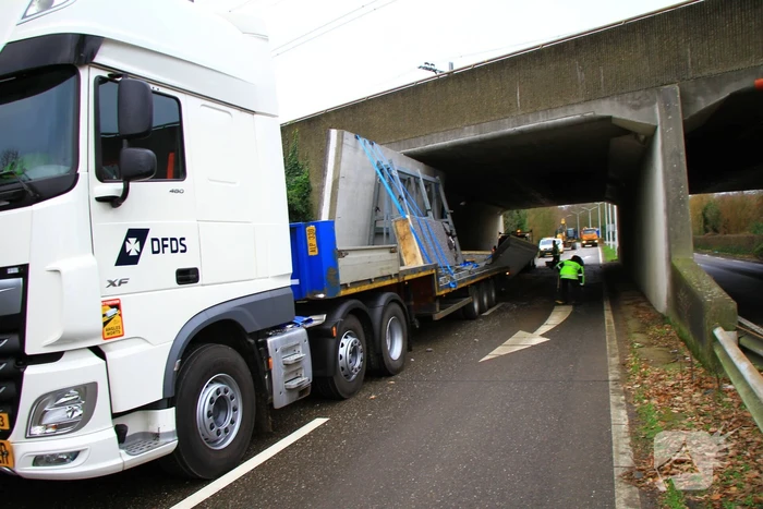 Vrachtwagenchauffeur rijdt met lading tegen spoorviaduct