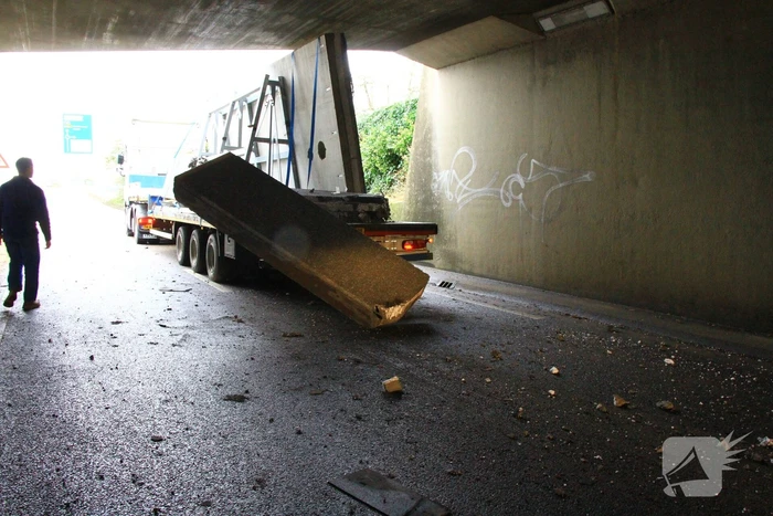 Vrachtwagenchauffeur rijdt met lading tegen spoorviaduct