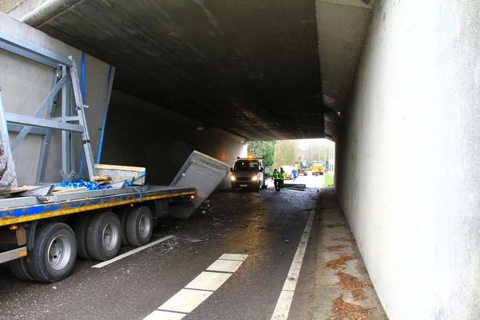 Vrachtwagenchauffeur rijdt met lading tegen spoorviaduct