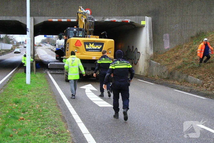 Vrachtwagenchauffeur rijdt met lading tegen spoorviaduct