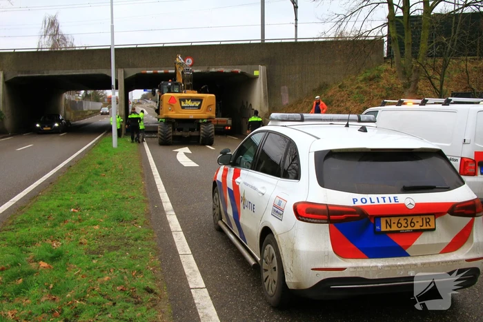 Vrachtwagenchauffeur rijdt met lading tegen spoorviaduct