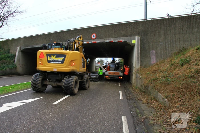 Vrachtwagenchauffeur rijdt met lading tegen spoorviaduct