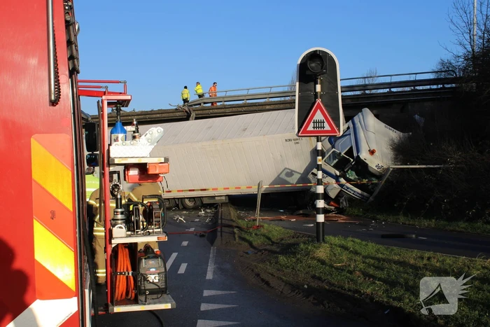 Vrachtwagen rijdt van snelweg af en plet bestelbus