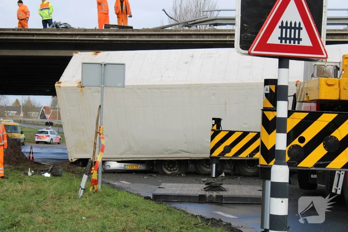 Vrachtwagen rijdt van snelweg af en plet bestelbus