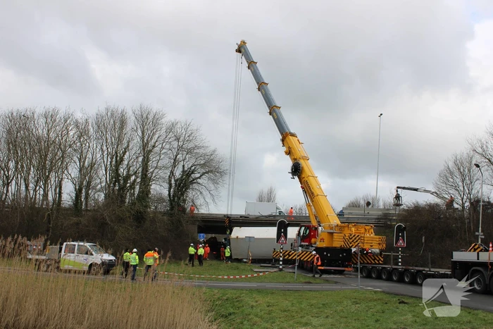 Vrachtwagen rijdt van snelweg af en plet bestelbus