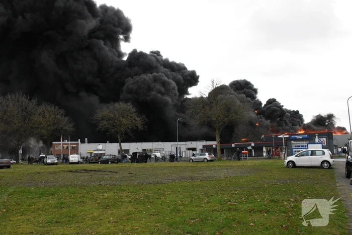 Zwarte rookwolken bij grote brand in bedrijfspand
