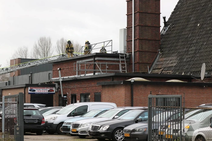 Auto vliegt in spuitcabine in brand