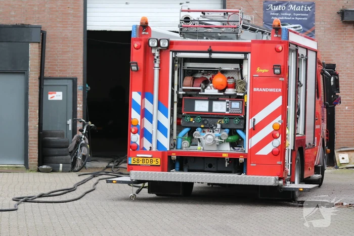 Auto vliegt in spuitcabine in brand