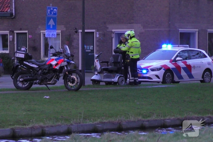Persoon met scootmobiel te water