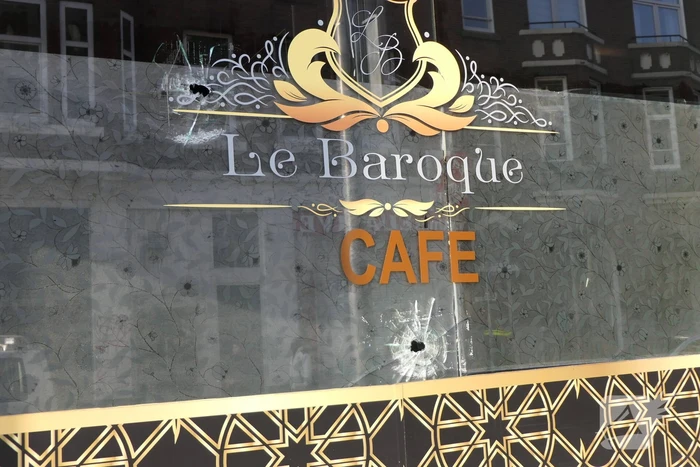 Kogelgaten in het raam van cafe Le Baroque
