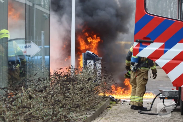Auto vliegt in brand voor ingang carwash