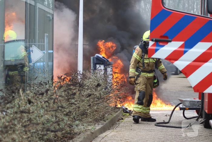 Auto vliegt in brand voor ingang carwash