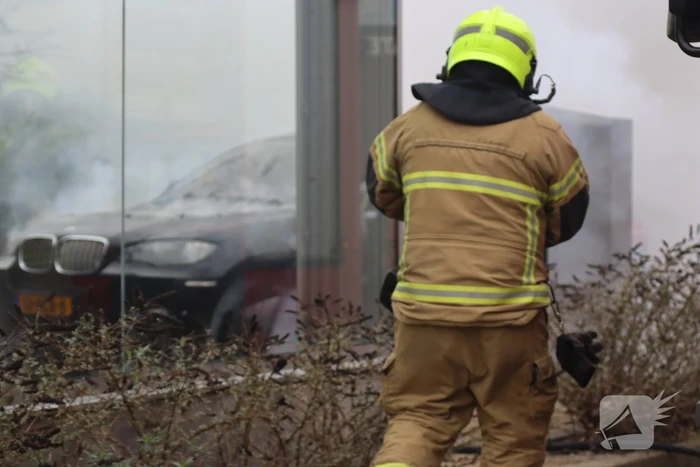 Auto vliegt in brand voor ingang carwash