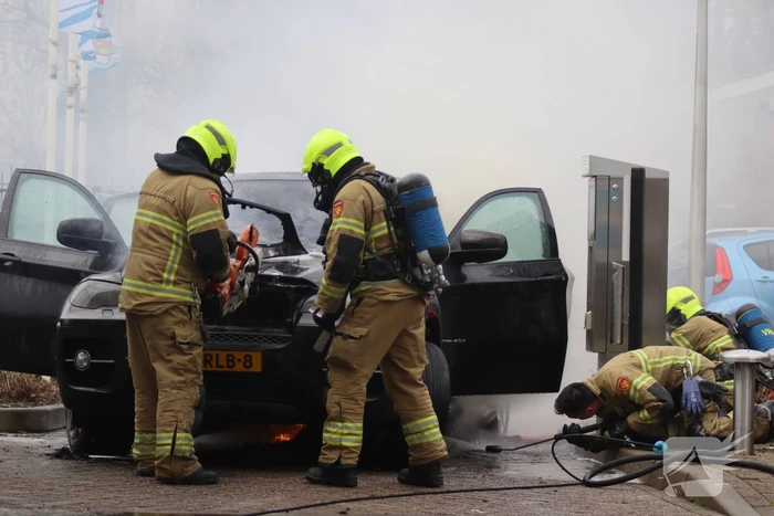 Auto vliegt in brand voor ingang carwash