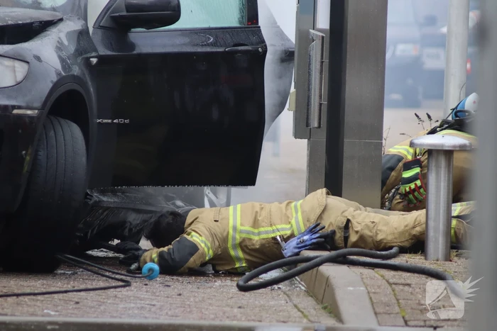 Auto vliegt in brand voor ingang carwash