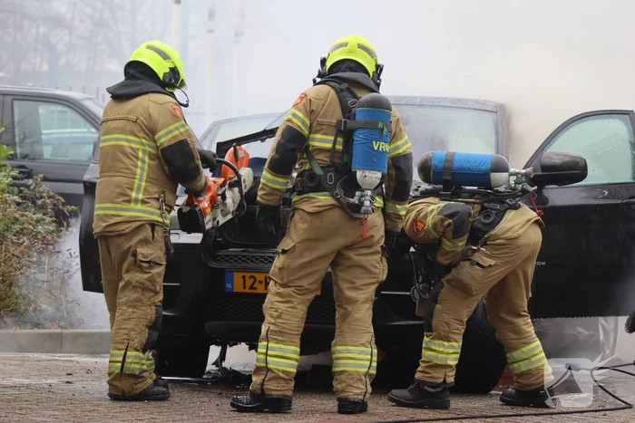 Auto vliegt in brand voor ingang carwash