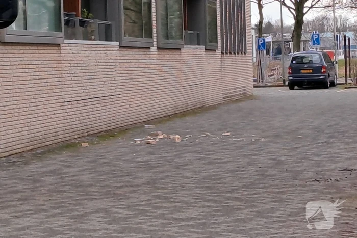 Bakstenen vallen uit gevel van flatgebouw