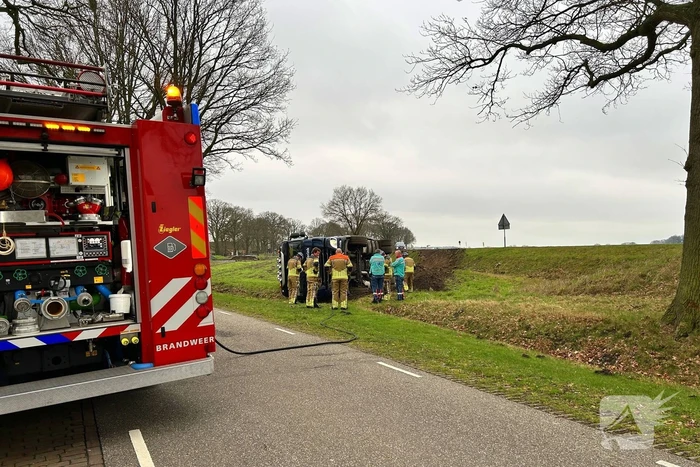 Vrachtwagen belandt op zijn kant naast de weg