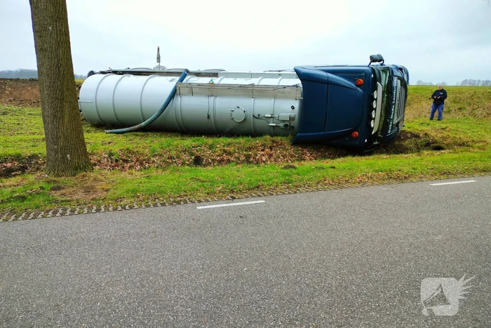 Vrachtwagen belandt op zijn kant naast de weg