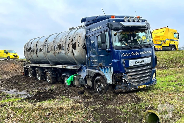 Vrachtwagen belandt op zijn kant naast de weg
