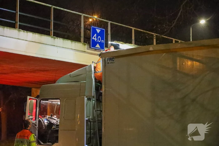 Te hoge vrachtwagen klem onder viaduct